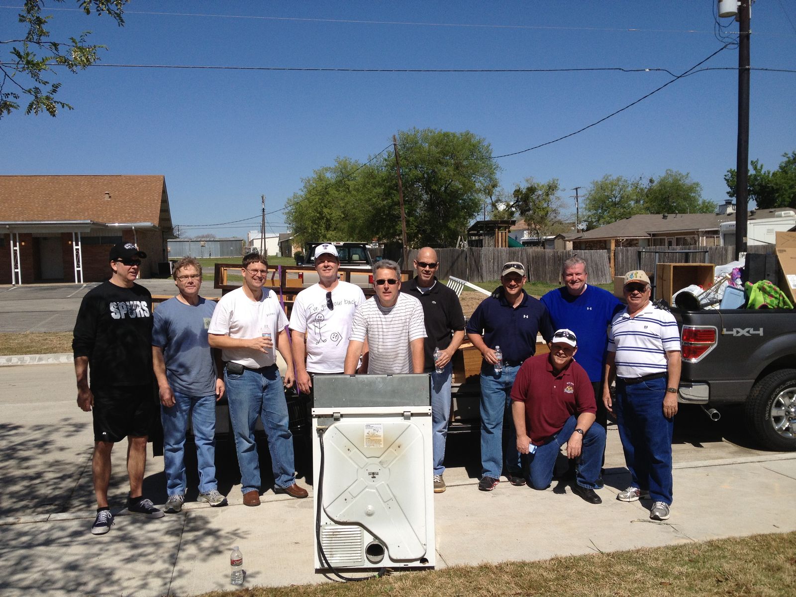Volunteers with a loaded pickup truck after hauling away old appliances